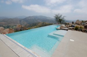 A striking blue infinity edge swimming pool overlooking San Diego.