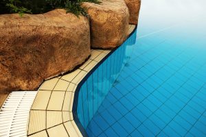 A close up of a pool that shows the pools coping and rock features.