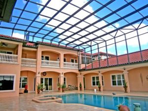 Luxurious multi-story pool enclosure on a sunny day.