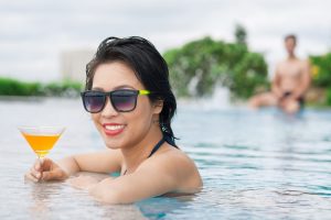 Woman in spa enjoying a cocktail while wearing sunglasses.