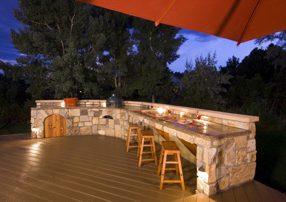 A backyard kitchen is integrated into the landscaping design.