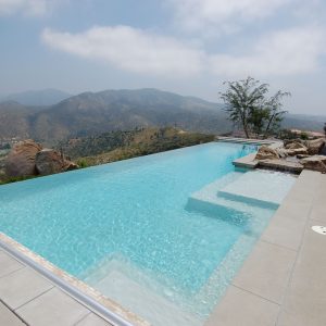 A striking blue infinity edge swimming pool overlooking San Diego.