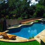 A modern pool and spa in residential backyard.