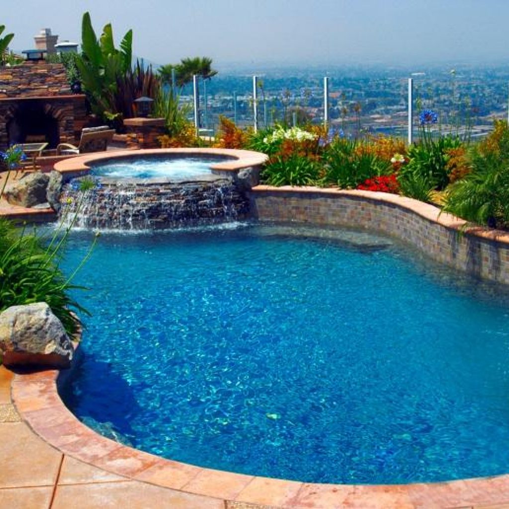 A freeform pool with a raised rock spa overlooking the San Diego landscape.