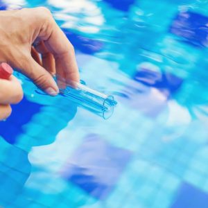 A person taken a sample of pool water to be tested.