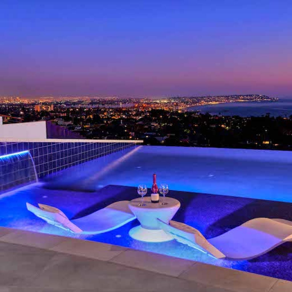 Zero edge pool at night overlooking the city and ocean