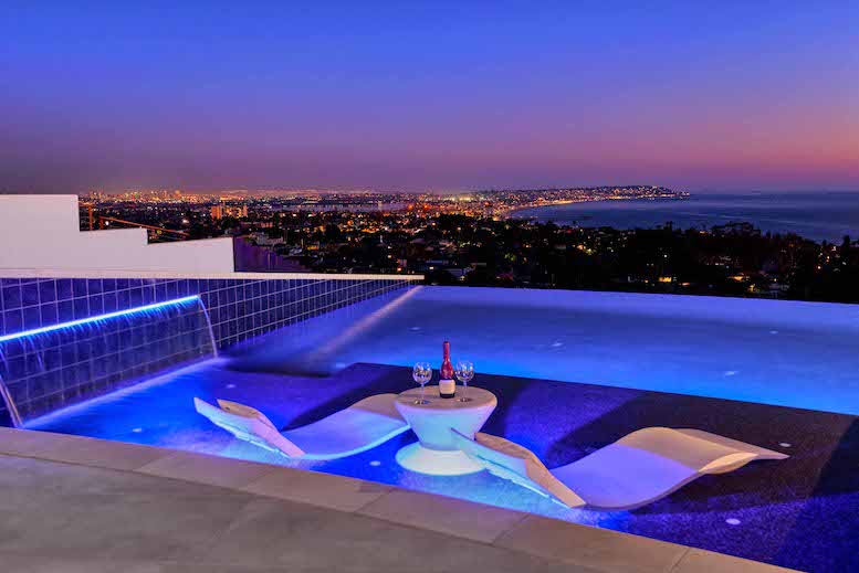 Zero edge pool at night overlooking the city and ocean