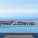 Zero edge pool at night overlooking the city and ocean in the daylight