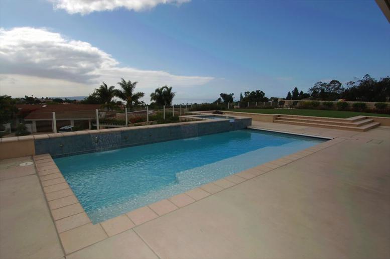 A geometric swimming pool with a cloudy sky in the background.