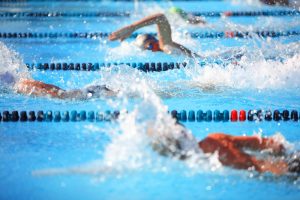 A close up hoto showing competitive swimmers doing a breast stroke.